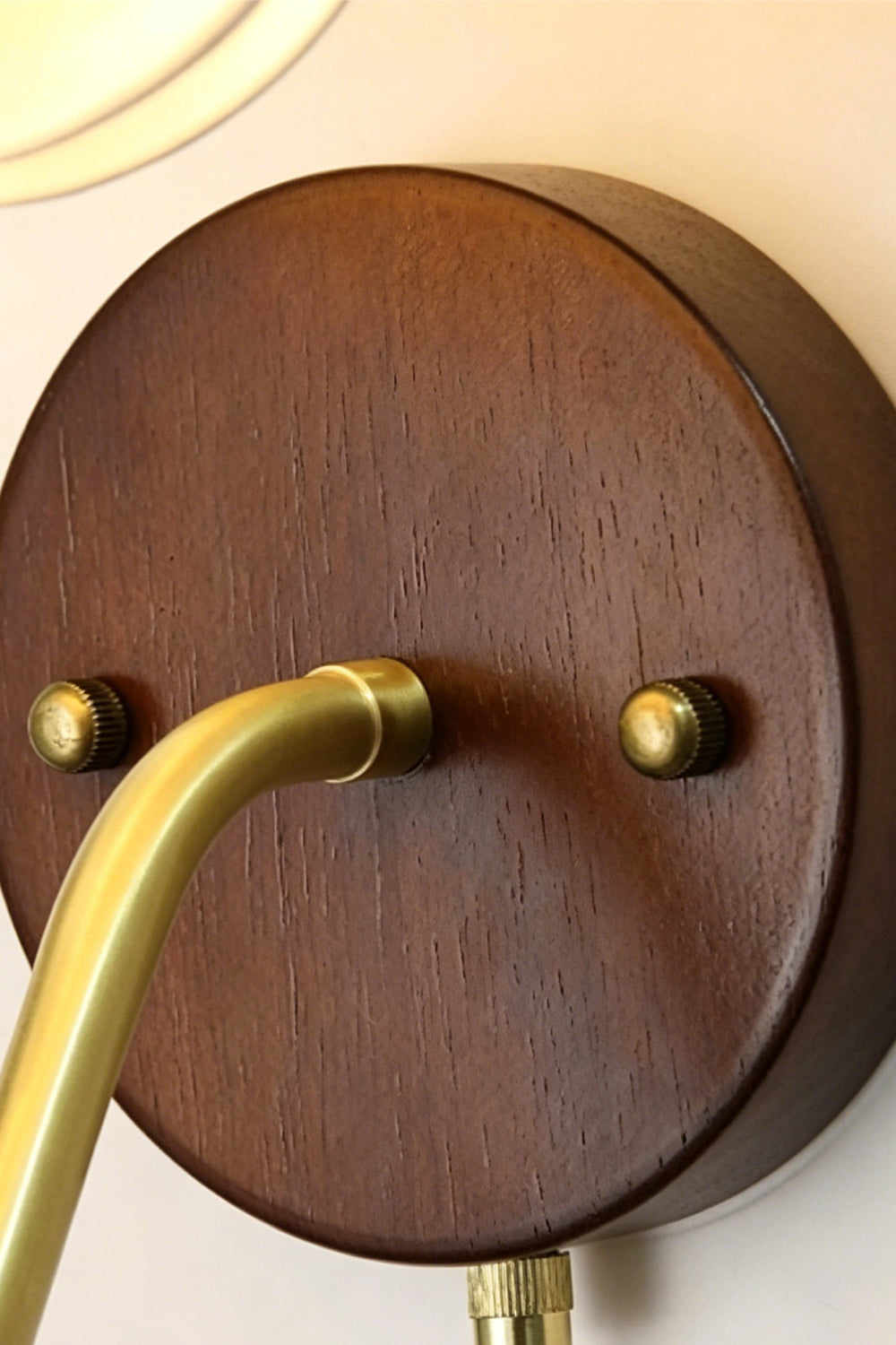 Baird Mid Century Pumpkin Wall Lamp | Metal, Fabric, Wood | Close-up detail of the circular dark wood wall canopy and brass connecting hardware | Detail shot | Samu Lamp