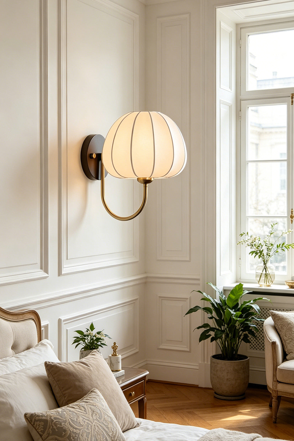 Baird Mid Century Pumpkin Wall Lamp | Metal, Fabric, Wood | Wall-mounted above a cozy lounge area with pillows and indoor plants in a classically decorated room | Samu Lamp