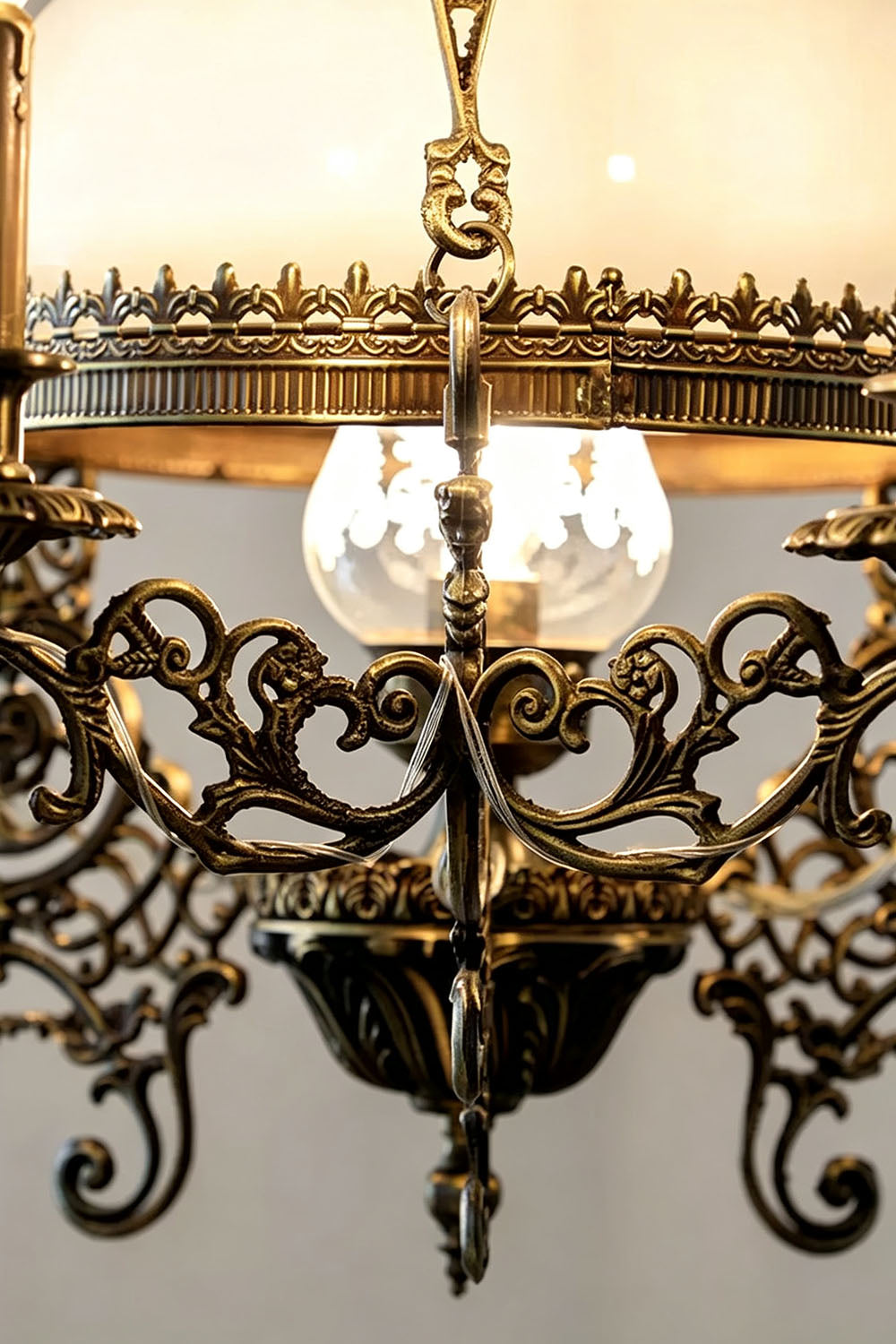 Close-up of the Barnaby Domed Glass Brass Chandelier showcasing ornate brass detailing and warm lighting.