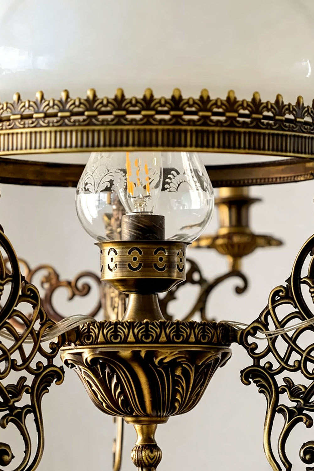 Close-up view of the Barnaby Domed Glass Brass Chandelier showcasing ornate brass details and glass elements.
