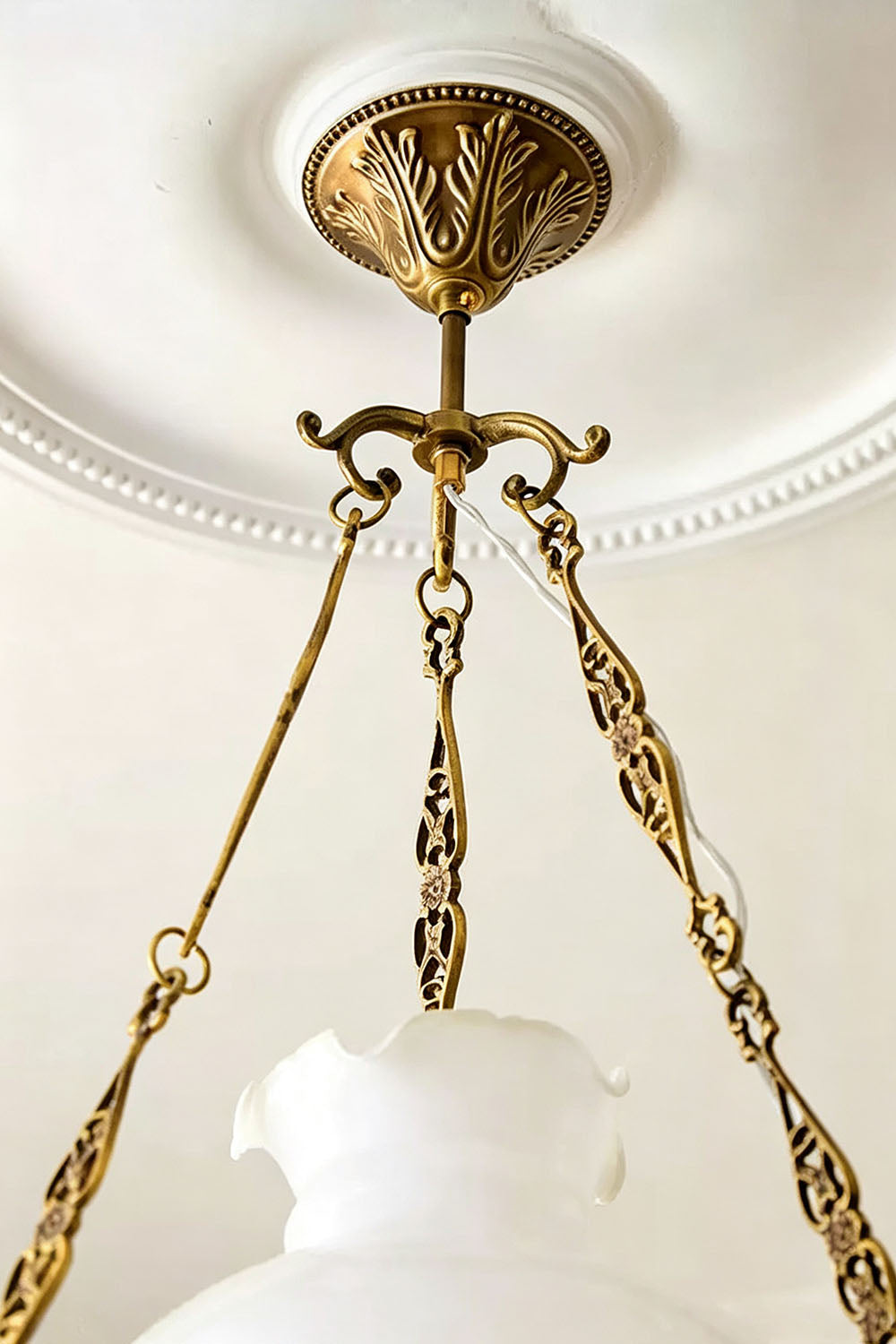 Close-up of the elegant brass fixture and chain of the Barnaby Domed Glass Brass Chandelier.