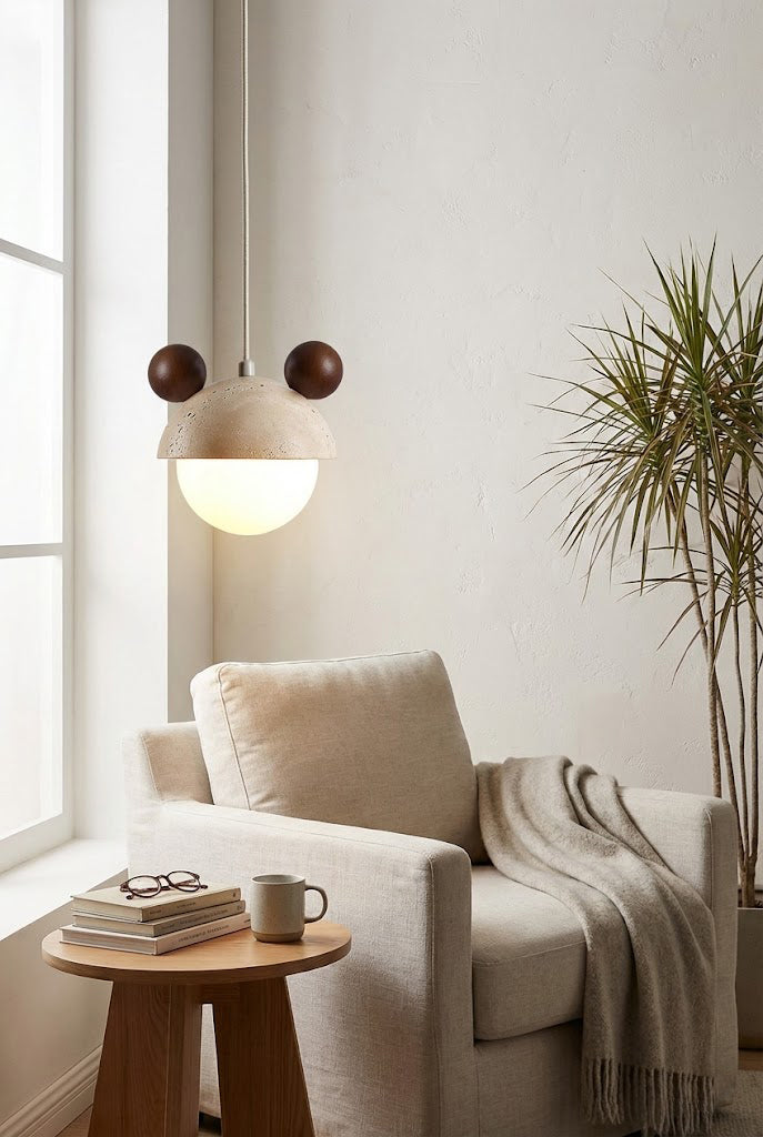 Modern bear ear pendant light in a reading corner | Travertine, Metal, Glass | Hanging near an armchair and side table | Samu Lamp