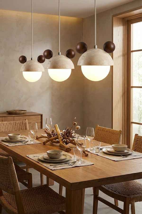 Trio of bear ear travertine pendants over a dining table | Travertine, Metal, Glass | Installed in a row in a modern dining room | Samu Lamp