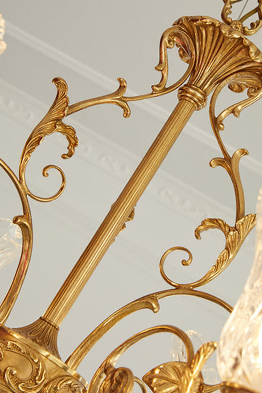 Beatrix Acanthus Leaf Chandelier | Ornate Brass and Frosted Carved Glass | Close-up view focusing on the decorative golden metal chain column decorated with delicate scrolls | Samu Lamp