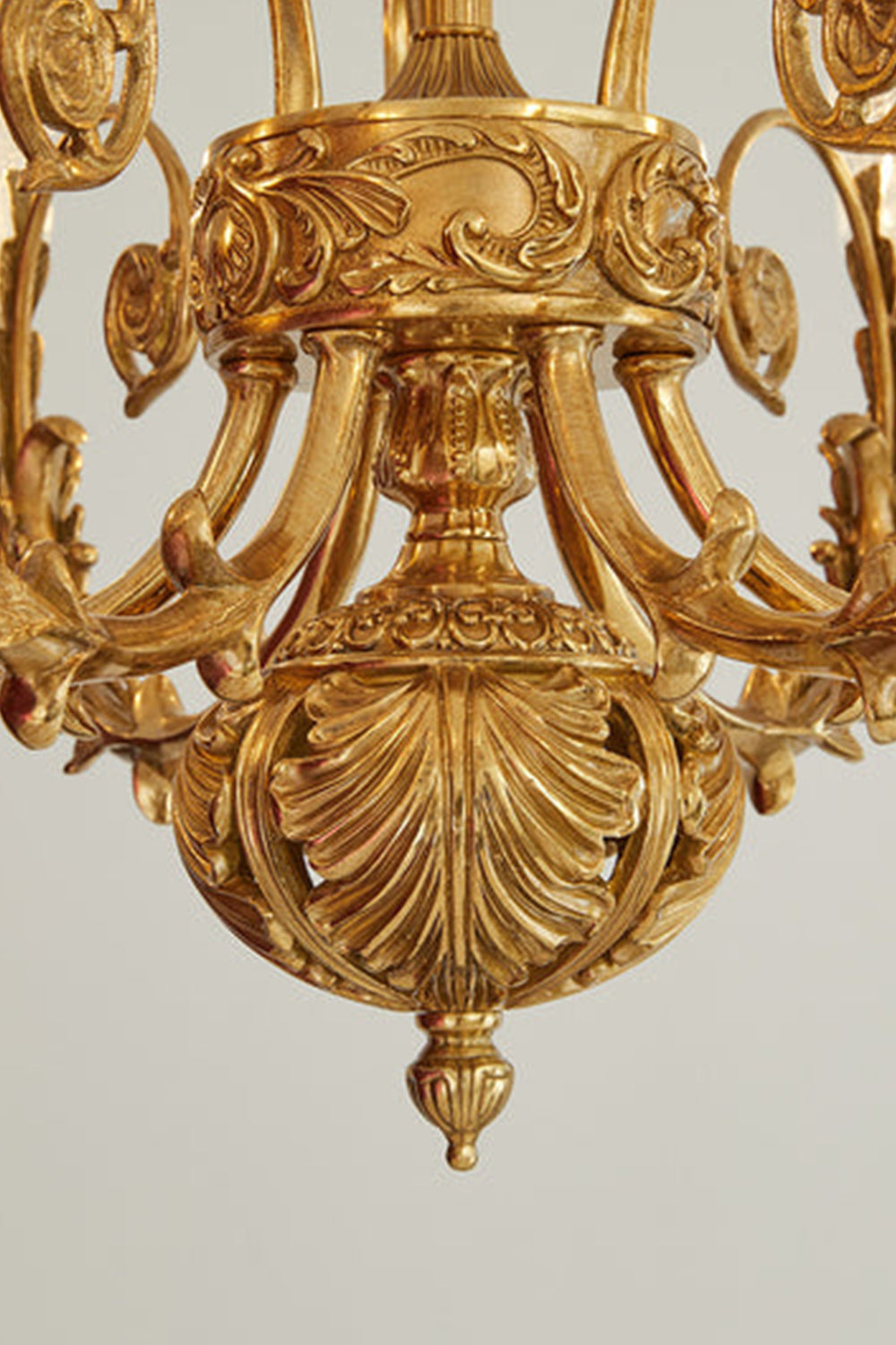 Beatrix Acanthus Leaf Chandelier | Ornate Brass and Frosted Carved Glass | Macro shot showcasing the elaborate acanthus leaf carvings on the central bottom brass ball finial | Samu Lamp