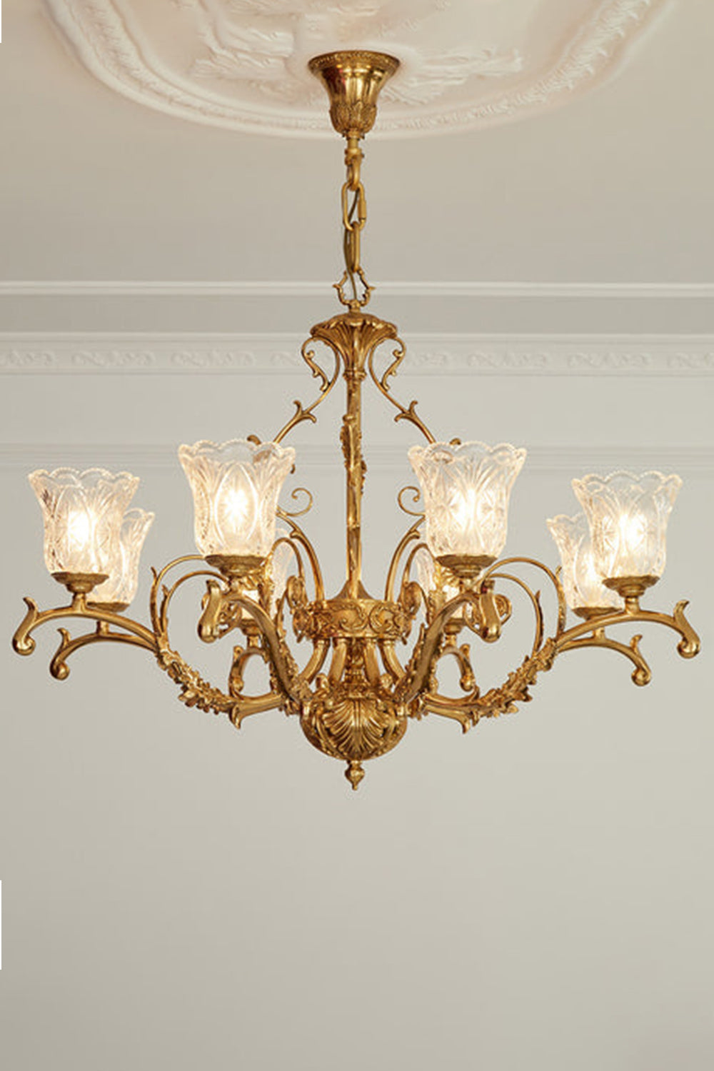 Beatrix Acanthus Leaf Chandelier | Ornate Brass and Frosted Carved Glass | Symmetrical view of the fully illuminated gold chandelier hanging from an ornate ceiling medallion | Samu Lamp