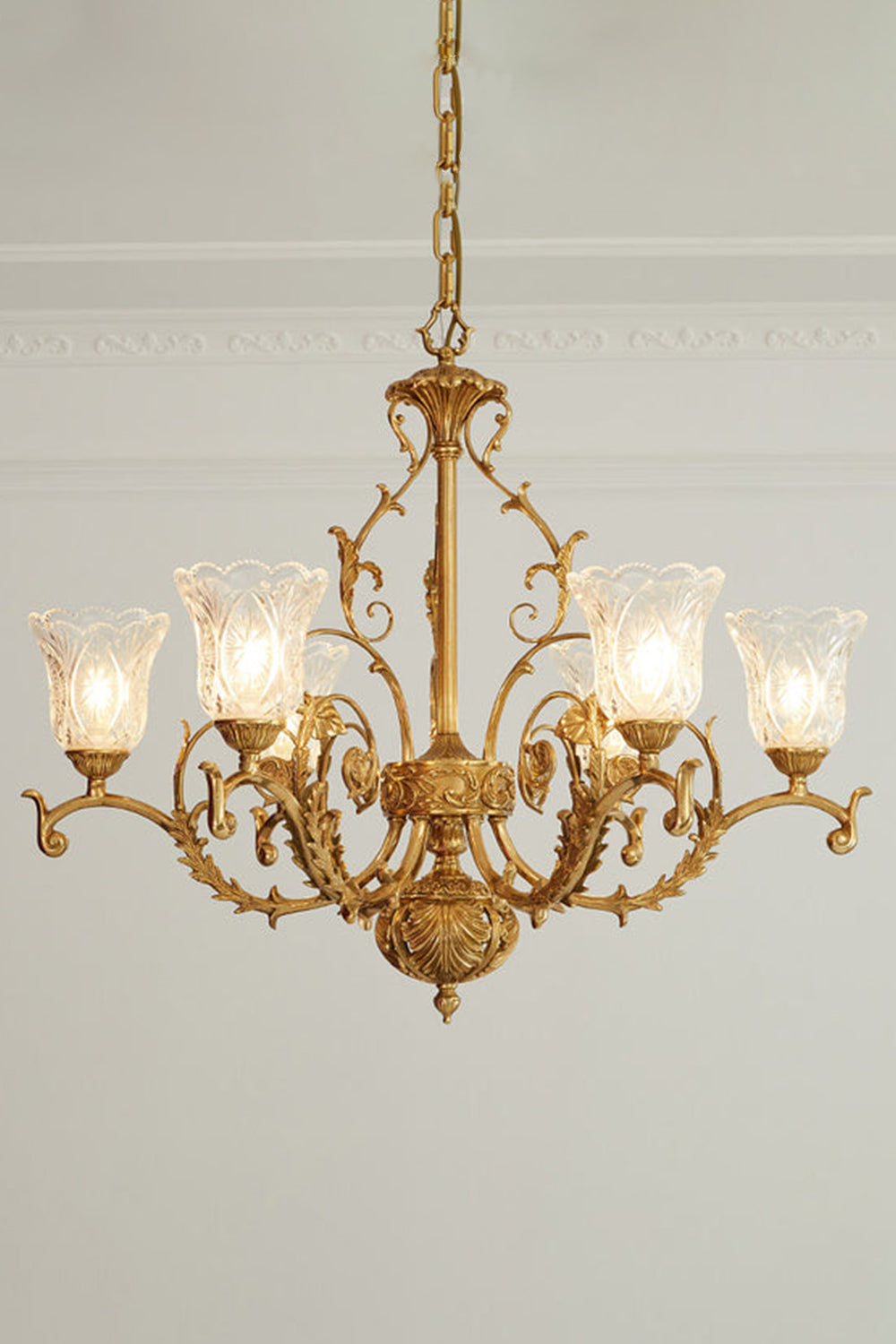 Beatrix Acanthus Leaf Chandelier | Ornate Brass and Frosted Carved Glass | Full studio presentation of the classic French-style brass fixture glowing warmly against a light wall | Samu Lamp