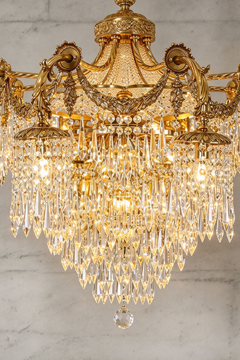 Belcastre Brass Crowned Crystal Cascade Chandelier | Cut Crystal and Brass | Close-up view of the cascading crystal prism basket glowing warmly | Samu Lamp