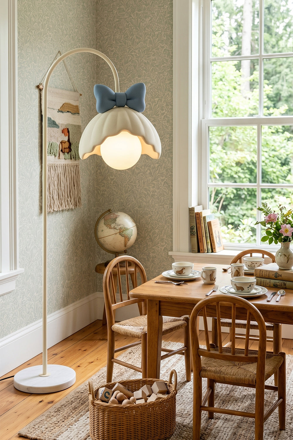 Bella Bow Arched Floor Lamp | Metal, Resin | Blue bow version casting a warm glow over a wooden child's activity table and chair set in a sunlit playroom | Samu Lamp