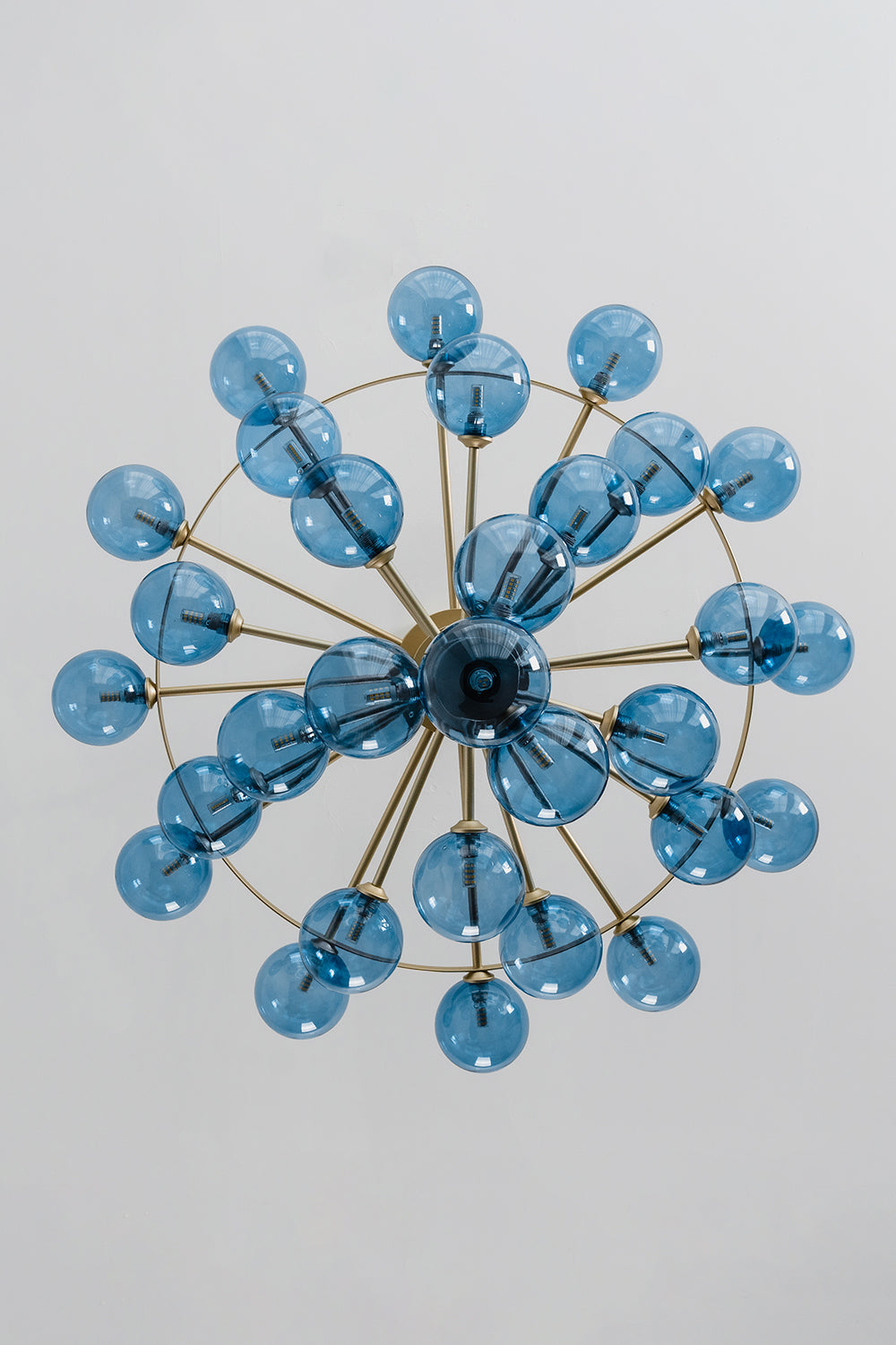 Blue Glass Bubble Globe Tiered Chandelier | Blue Glass and Brass Metal | Directly underneath bottom-up view displaying the radial starburst pattern of the blue spheres | Samu Lamp