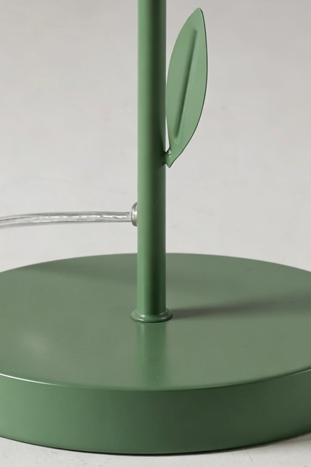 Base and stem close-up detail | Metal | Red/Yellow petal botanical lamp | Circular green base, stem, leaf detail | Power cord visible | Samu Lamp