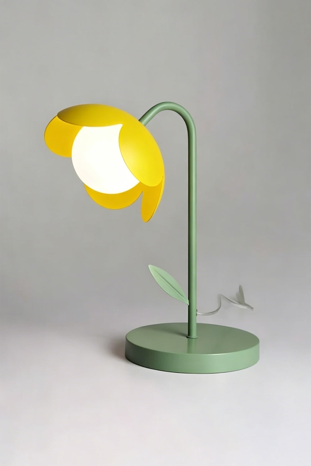 Isolated red botanical table lamp | Metal and glass | Stylized tulip shape with green base, red petals, white globe | Light grey background | Front angular view | Samu Lamp