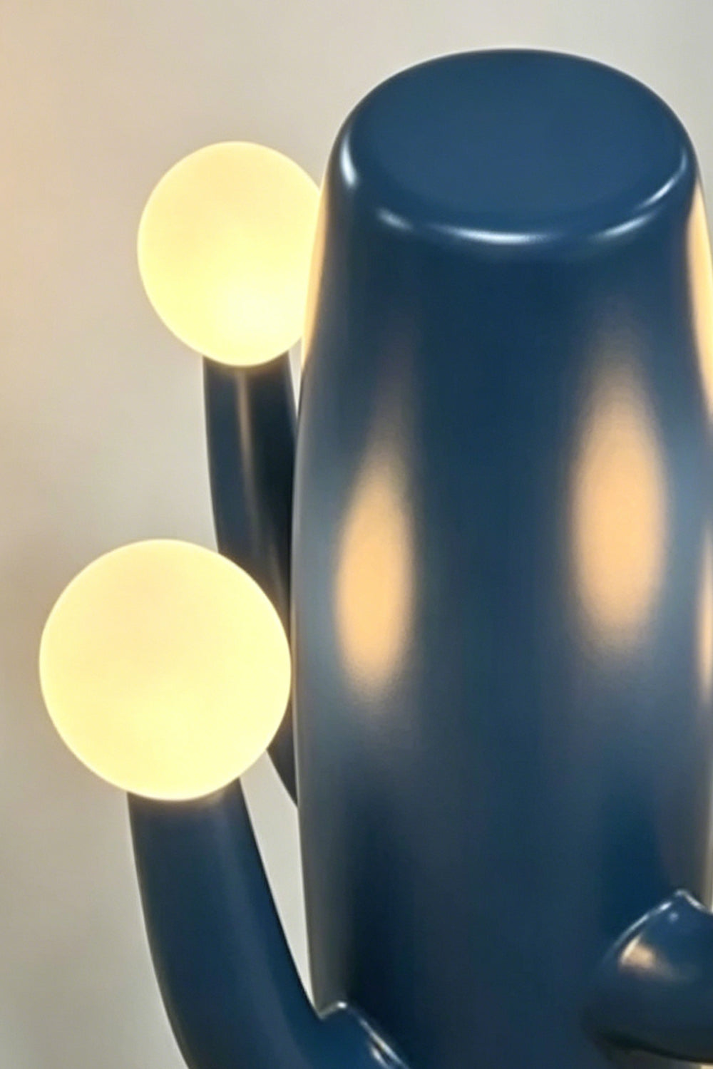 A top-down perspective view focusing on the top cluster of the blue cactus lamp, showing the three lit spherical bulbs.