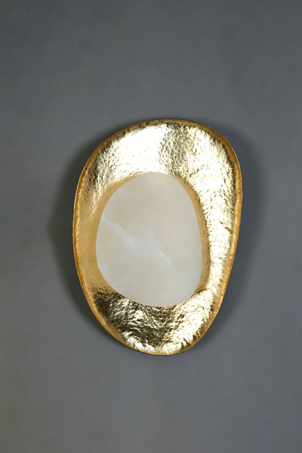 Caeliform Aurelia Alabaster Wall Lamp | Alabaster, Brass | The lamp mounted on a dark grey, textured feature wall for a dramatic, moody contrast | Isolated product shot | Samu Lamp