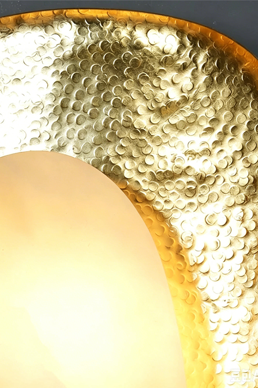 Caeliform Aurelia Alabaster Wall Lamp | Alabaster, Brass | Macro view highlighting the detailed hand-pounded texture of the gold brass frame against the stone element | Close-up | Samu Lamp