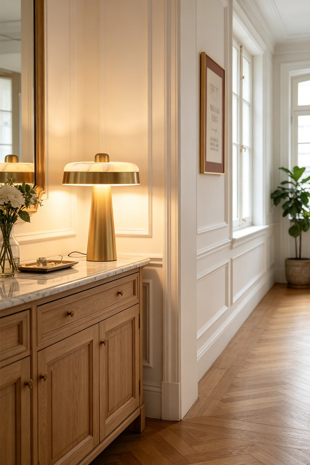 Callista Alabaster Disc Table Lamp | Hallway Console Light | Placed elegantly on a long light wood console cabinet along a white paneled wall hallway corridor | Samu Lamp