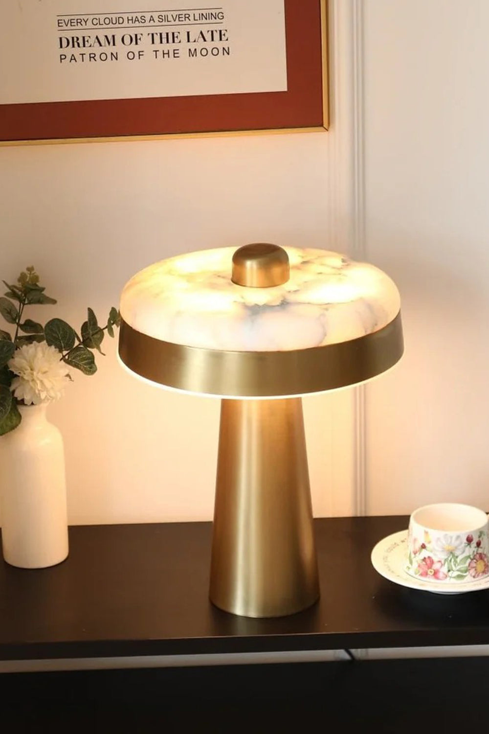 Callista Alabaster Disc Table Lamp | Lit Studio View | Detailed view of the fully illuminated stone disc table lamp casting a warm downward halo on a black table surface | Samu Lamp