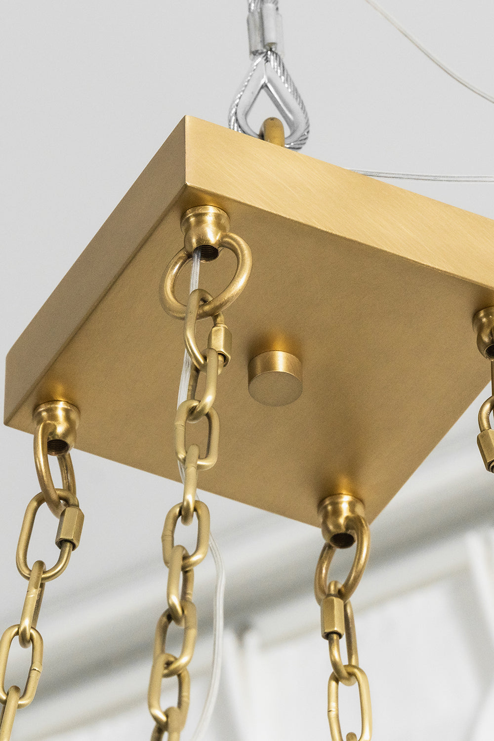 Callista Tiered Alabaster Chandelier | Alabaster, Metal | Close-up focus on the square brushed gold brass ceiling canopy plate and the heavy-duty loop ring connections with chain links | Detail shot | Samu Lamp