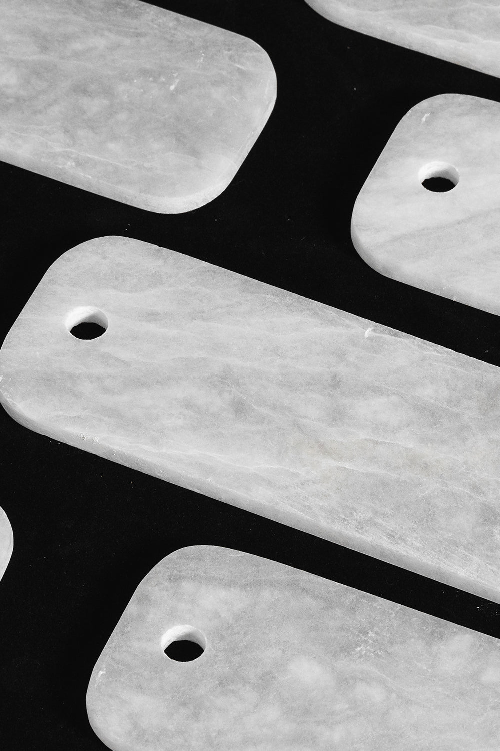 Callista Tiered Alabaster Chandelier | Alabaster, Metal | Macro close-up view of loose rectangular white alabaster stone plates showcasing their pre-drilled holes and natural mineral cloud patterns | Detail shot | Samu Lamp