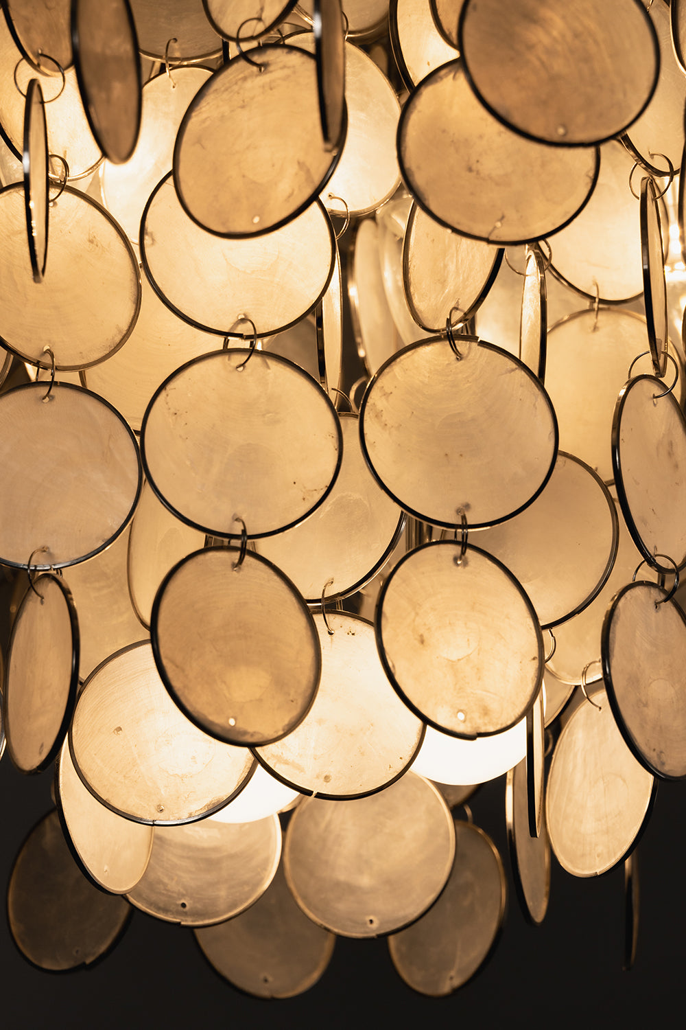 Close-up of lit natural Capiz shell discs | Shell | Detailed view of iridescent texture and metal rings | Samu Lamp