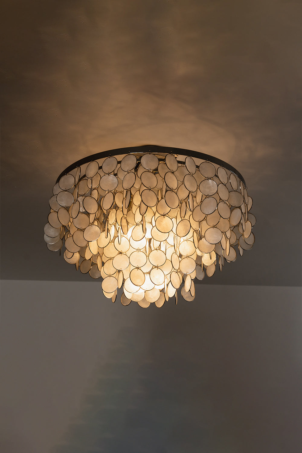 Soft-glow Capiz shell disc light | Shell | Iron | Close-up of the lamp from below showing light diffusion | Samu Lamp