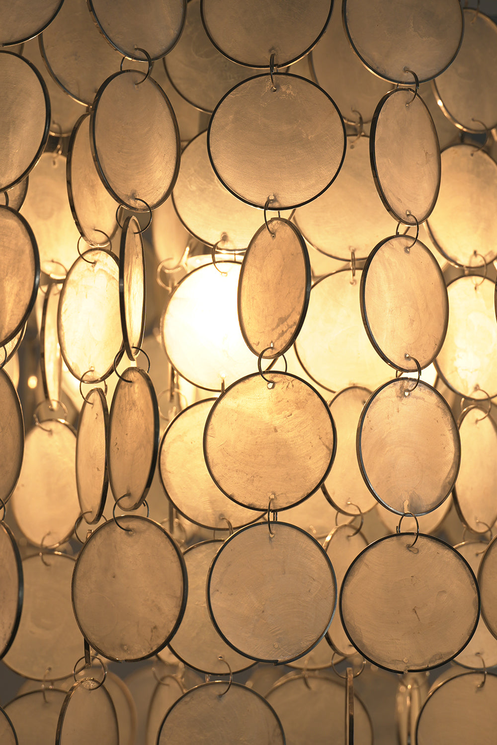 Close-up of glowing Capiz shell discs | Shell | Detail shot of warm illumination through translucent shells | Samu Lamp