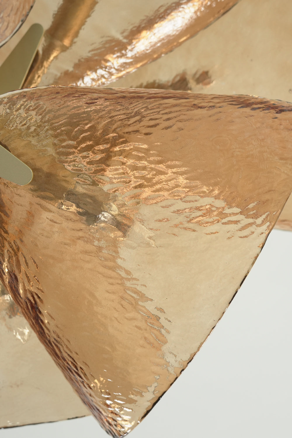 Detailed view of amber textured hammered glass petal | Glass | Showing the light-refracting surface patterns | Samu Lamp