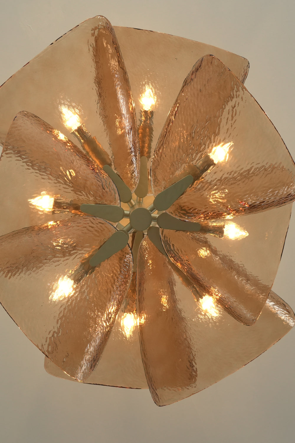 Lit Cardiff Textured Wave Chandelier from below | Metal, Glass | Showing the petal arrangement and warm bulbs | Samu Lamp