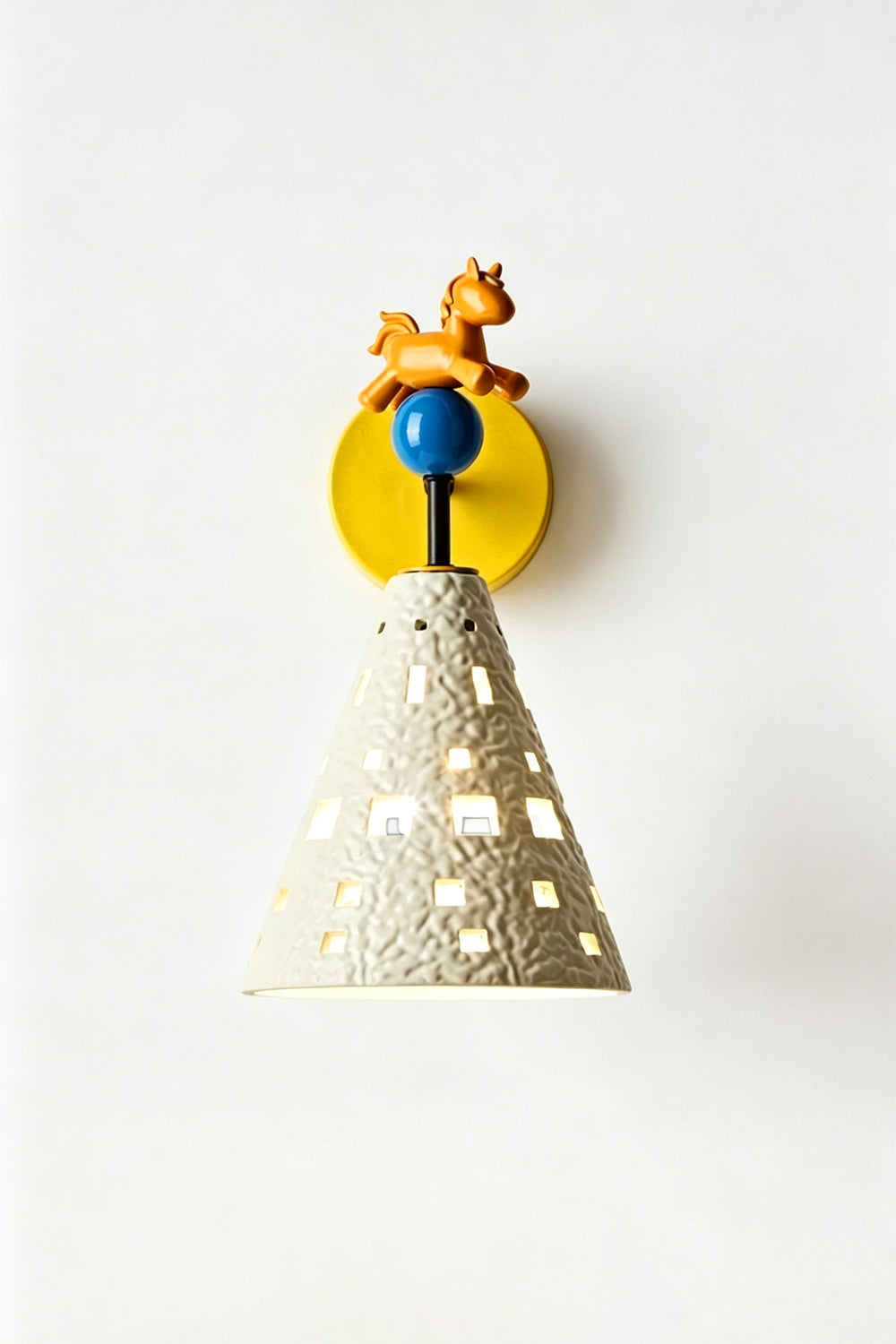 Carousel Horizon Ceramic Wall Sconce | Metal, Resin, Ceramics | Frontal view of the fully lit sconce against a plain wall, showing light filtering through the perforated shade | Isolated shot | Samu Lamp