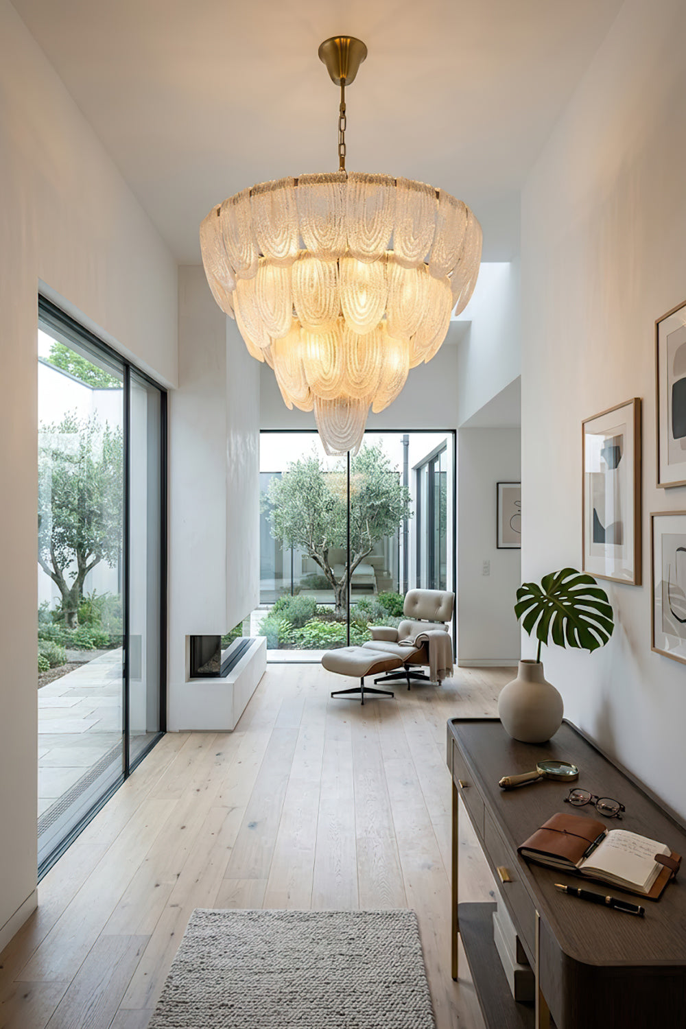 Glass petal chandelier at the end of a corridor | Metal, Glass | Installed in a bright hallway over a wooden console | Samu Lamp