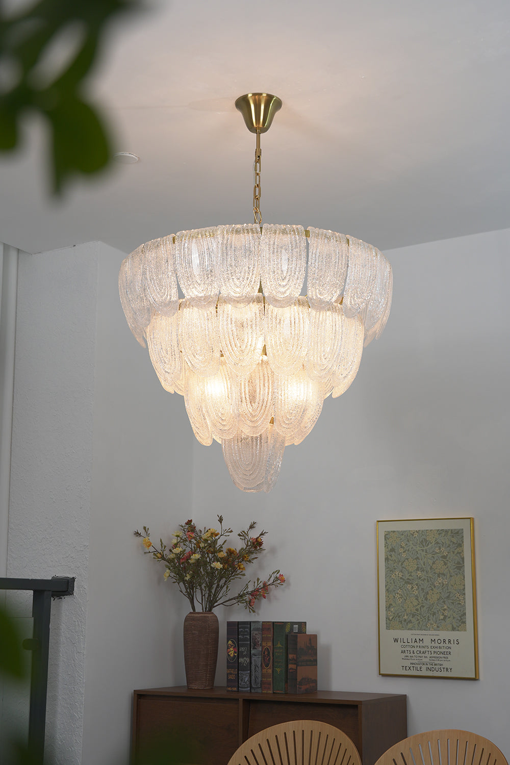 Warm glow glass petal pendant light | Metal, Glass | Installed in a living room corner over a wooden cabinet | Samu Lamp