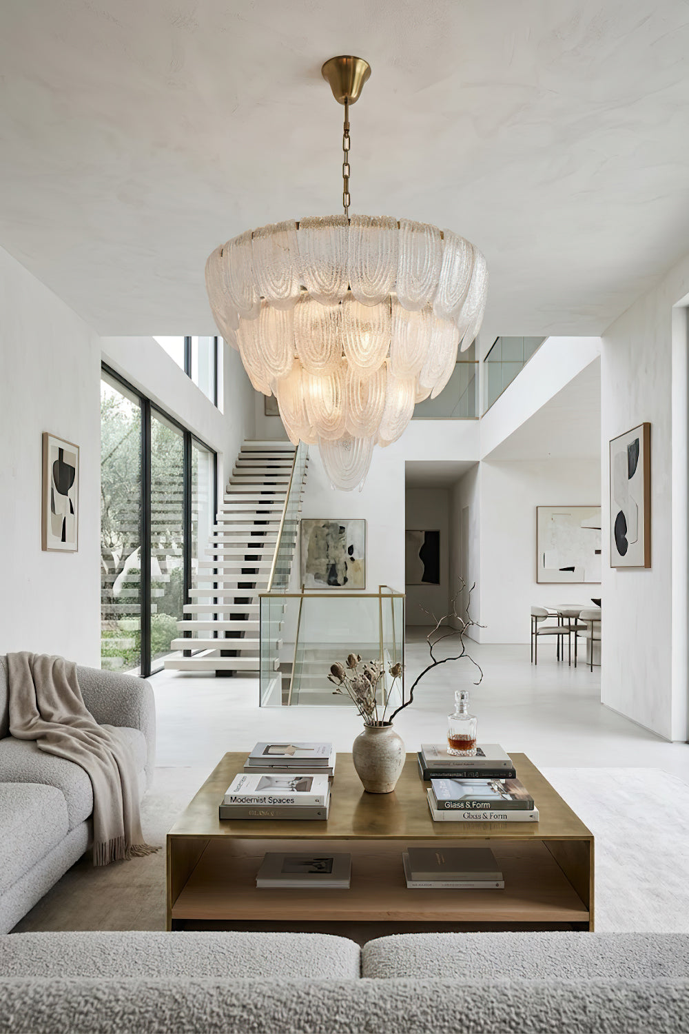 Luxurious glass petal chandelier in open-plan home | Metal, Glass | Centered over a coffee table in a bright modern living area | Samu Lamp