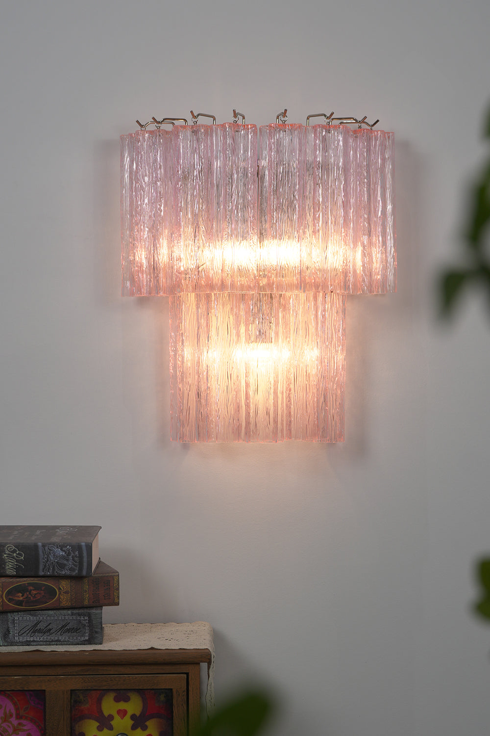 Cascading Prism Pink Glass Wall Light | Glass, Metal | Front view of the fully lit pink glass lamp creating a warm, soft glow | Isolated shot | Samu Lamp Cascading Prism