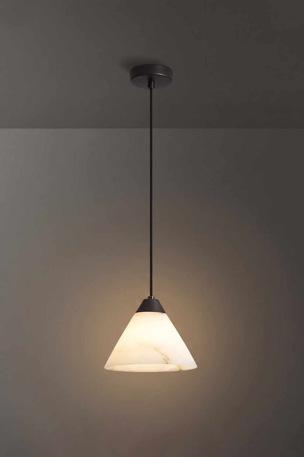 Caspian Conical Alabaster Pendant Light | Natural Alabaster and Black Metal | Full studio view of the illuminated cone fixture featuring a matte black rod option | Samu Lamp