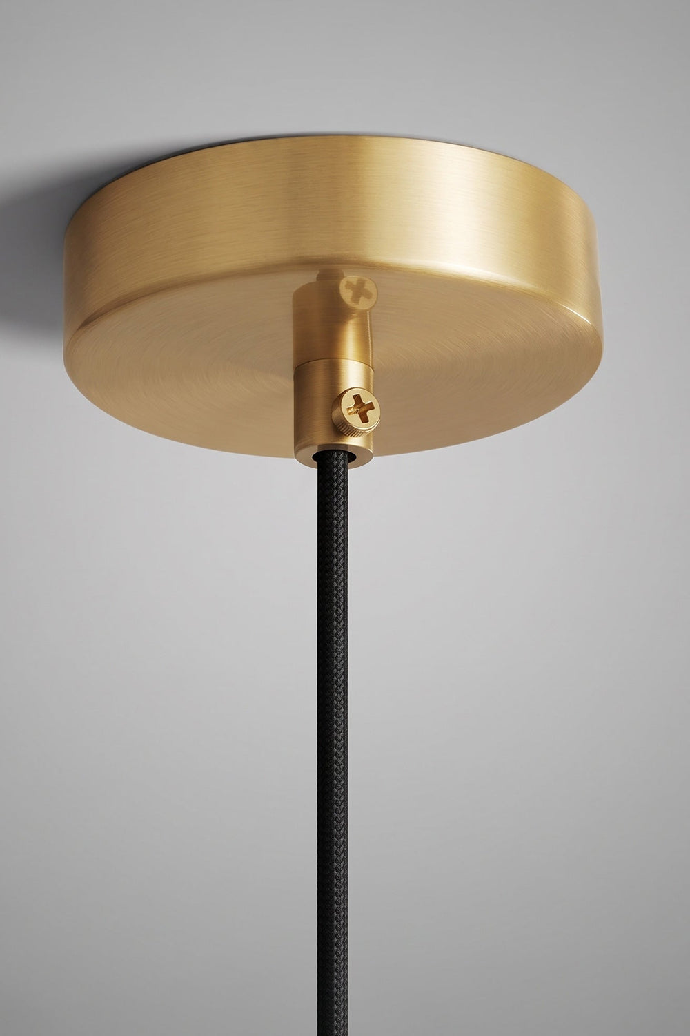 Caspian Conical Alabaster Pendant Light | Natural Alabaster and Brass | Close-up macro shot focusing on the round polished gold metal ceiling canopy and black cord | Samu Lamp