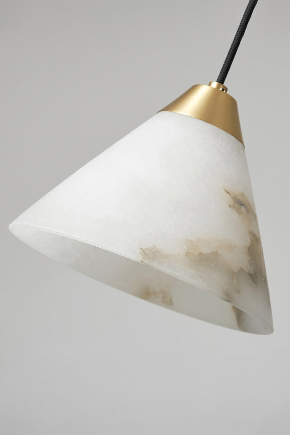 Caspian Conical Alabaster Pendant Light | Natural Alabaster and Brass | Macro texture close-up showcasing the unlit white stone shade and the golden metal top connection | Samu Lamp