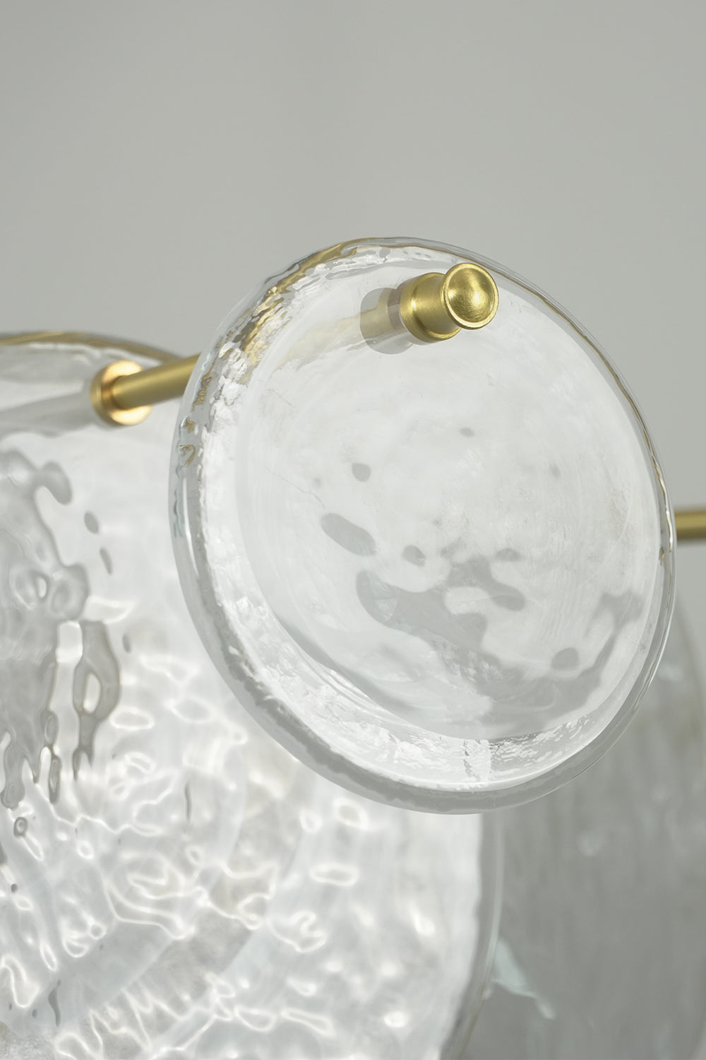 English: Celeste Glass Disc Chandelier | Glass, Metal | Macro close-up under bright light highlighting the unique crinkled ice texture of the clear glass disc plate | Detail shot | Samu Lamp