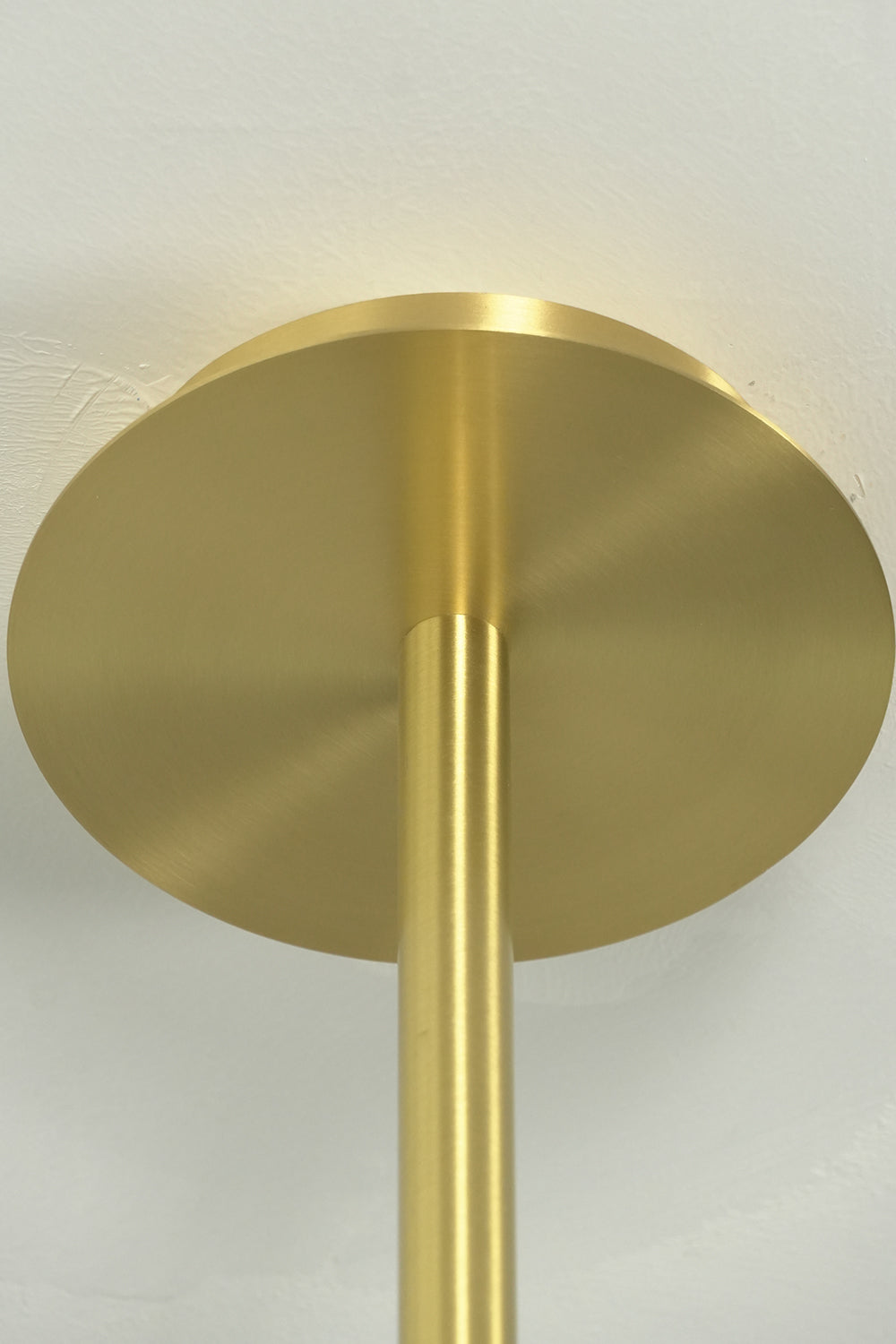 English: Celeste Glass Disc Chandelier | Glass, Metal | Close-up focus on the minimalist round brushed gold brass ceiling canopy and vertical downrod installation | Detail shot | Samu Lamp