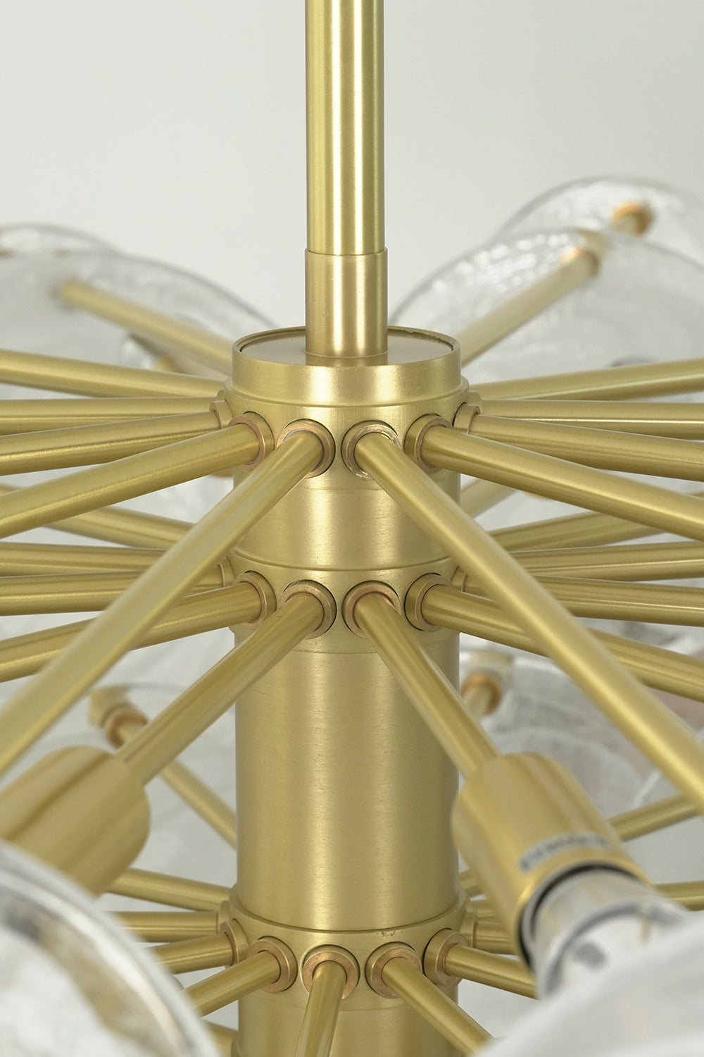English: Celeste Glass Disc Chandelier | Glass, Metal | Up-close structural view of the brushed gold brass central sphere core and radial frame spokes with sockets | Detail shot | Samu Lamp