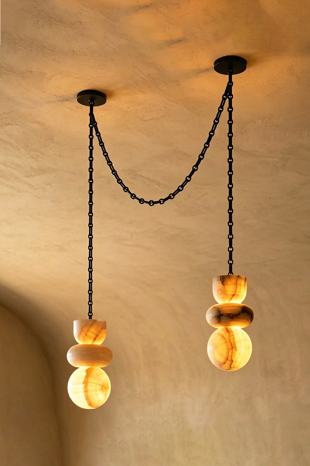 Celestial Alabaster Chandelier | Alabaster, Metal | Two-light swag arrangement on textured wall | Samu Lamp