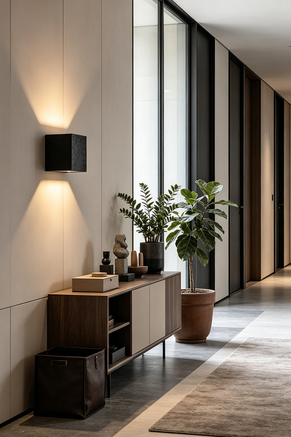 Celestial Tectonic Black Travertine Wall Lamp | Black Travertine | Placed in a gallery hallway near a wooden console | Samu Lamp
