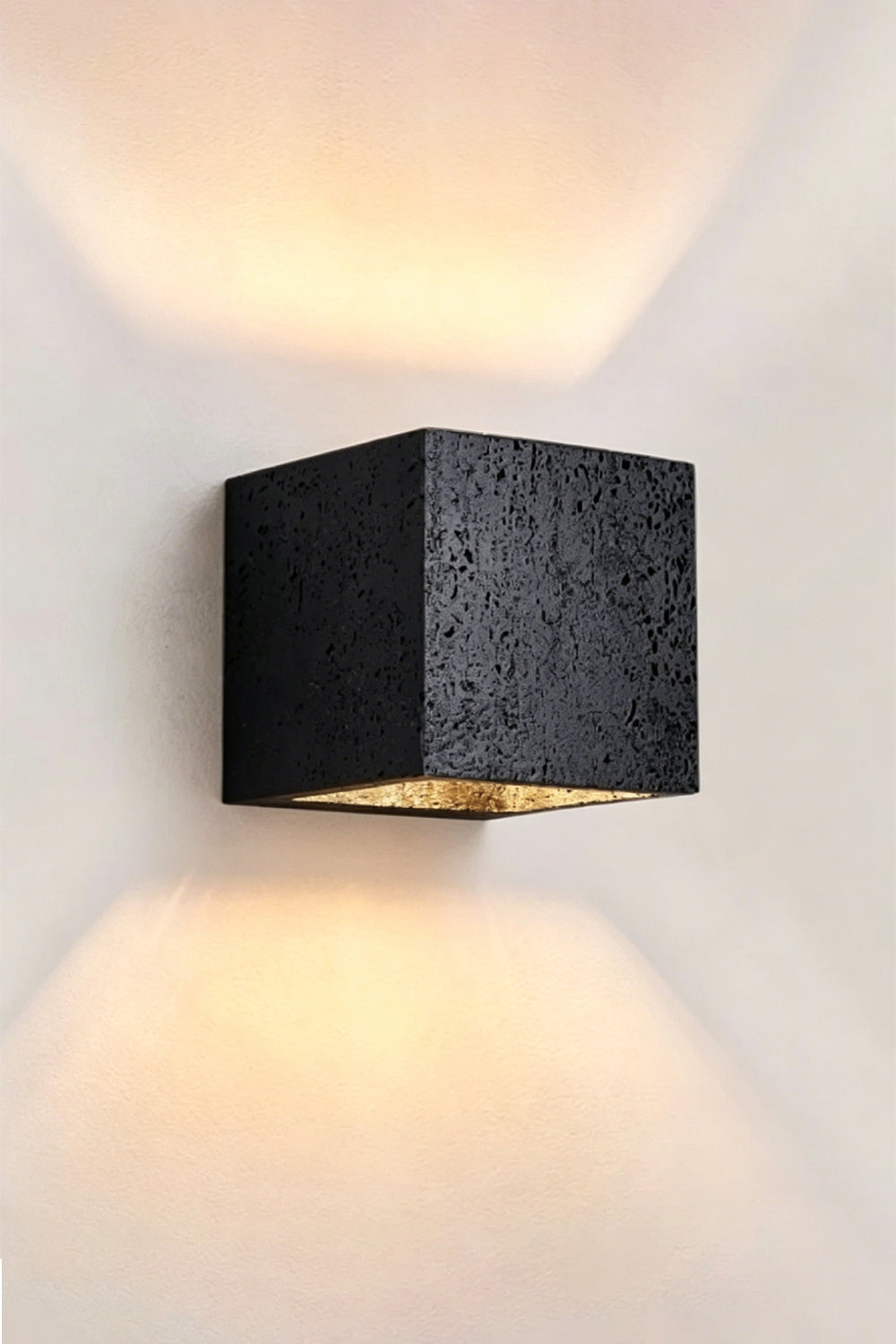 Celestial Tectonic Black Travertine Wall Lamp | Black Travertine | Angled perspective showing stone surface and warm glow | Samu Lamp