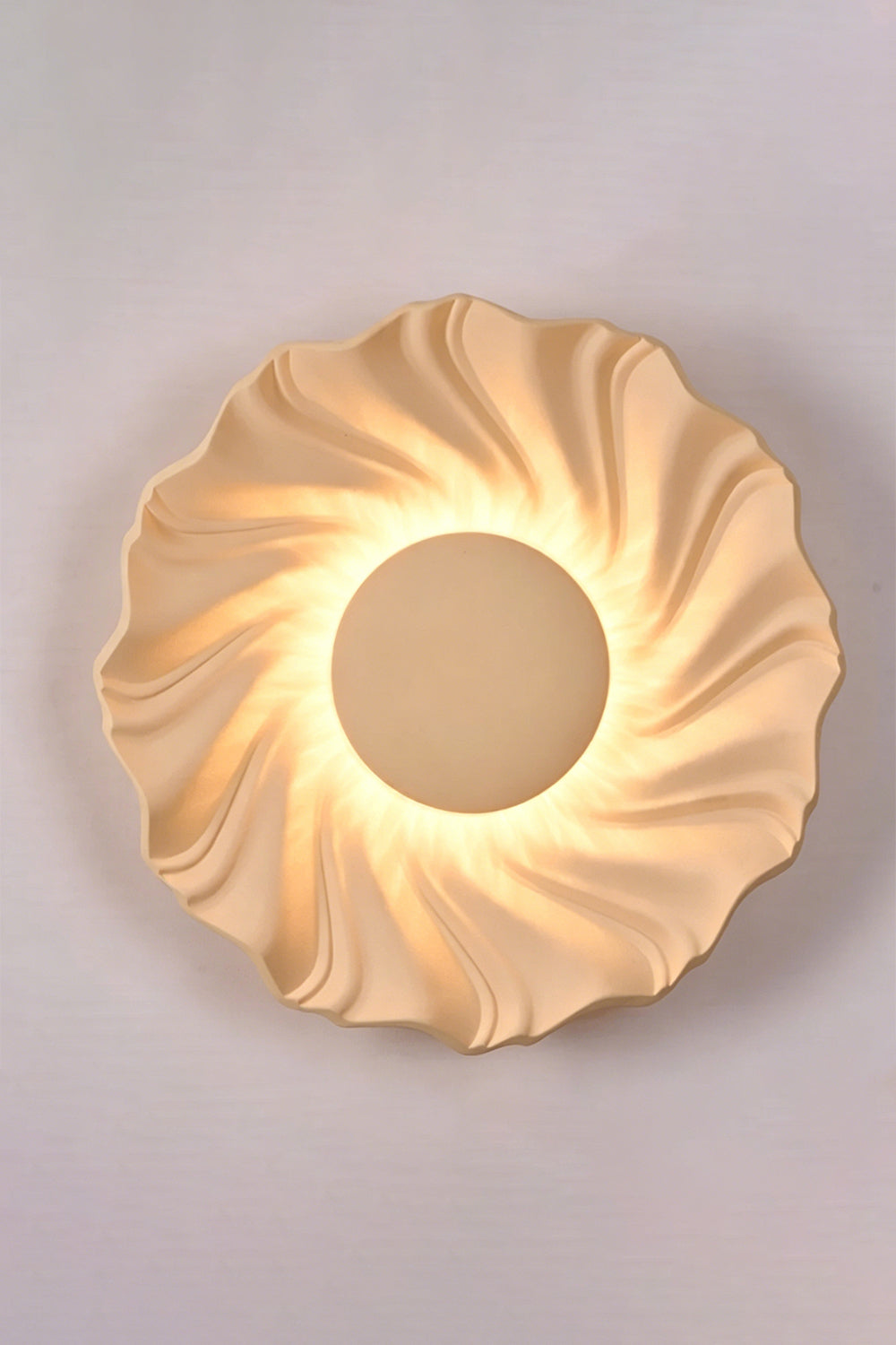 Centripetal Solstice Metal Wall Lamp | Metal, Resin | Creamy coffee textured lamp on a plain background, providing soft light | Isolated lit variant shot | Samu Lamp