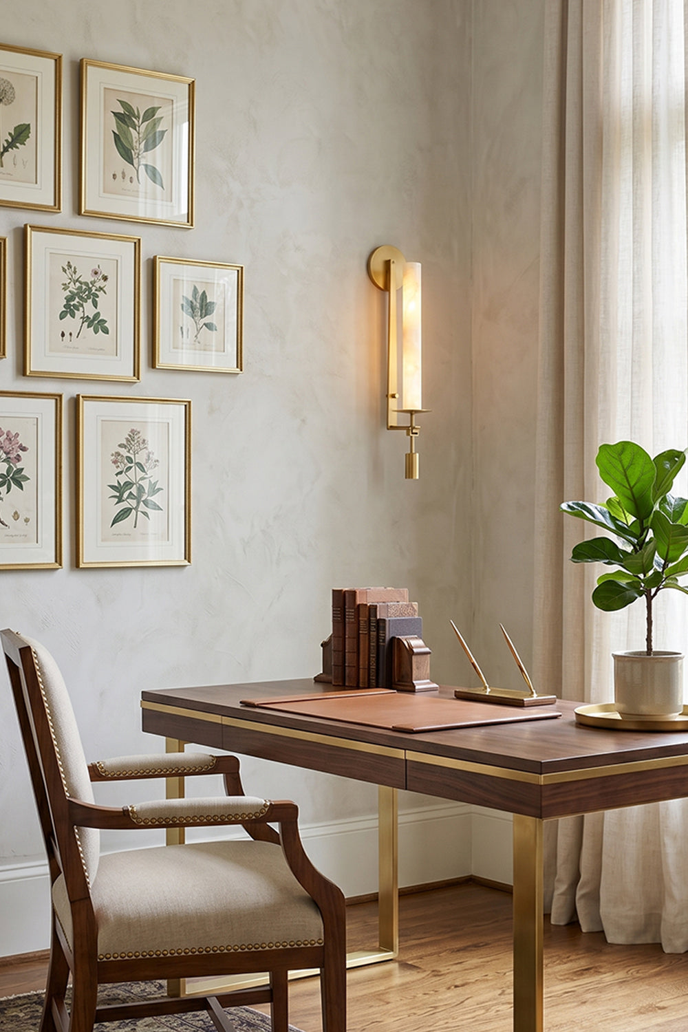 Chantal Twin Alabaster Wall Sconce | Alabaster, Brass | Staged gracefully on a light grey wall over a wooden study desk, flanked by botanical framed wall art prints | Samu Lamp