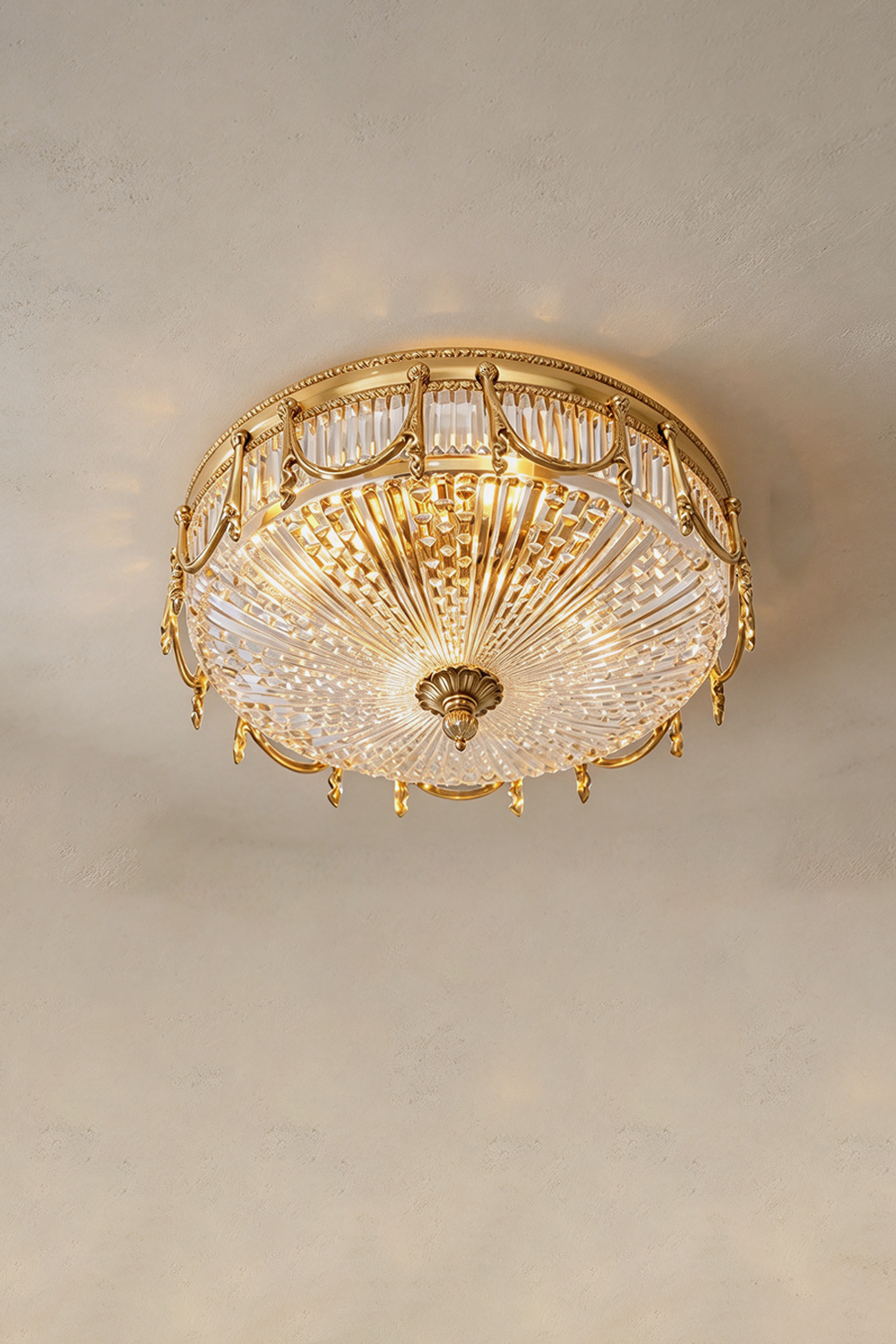 Chaumelle Brass Swag Ribbed Glass Ceiling Light | Ribbed Glass and Brass | Angled view of the flush mount variant illuminated on a neutral ceiling | Samu Lamp