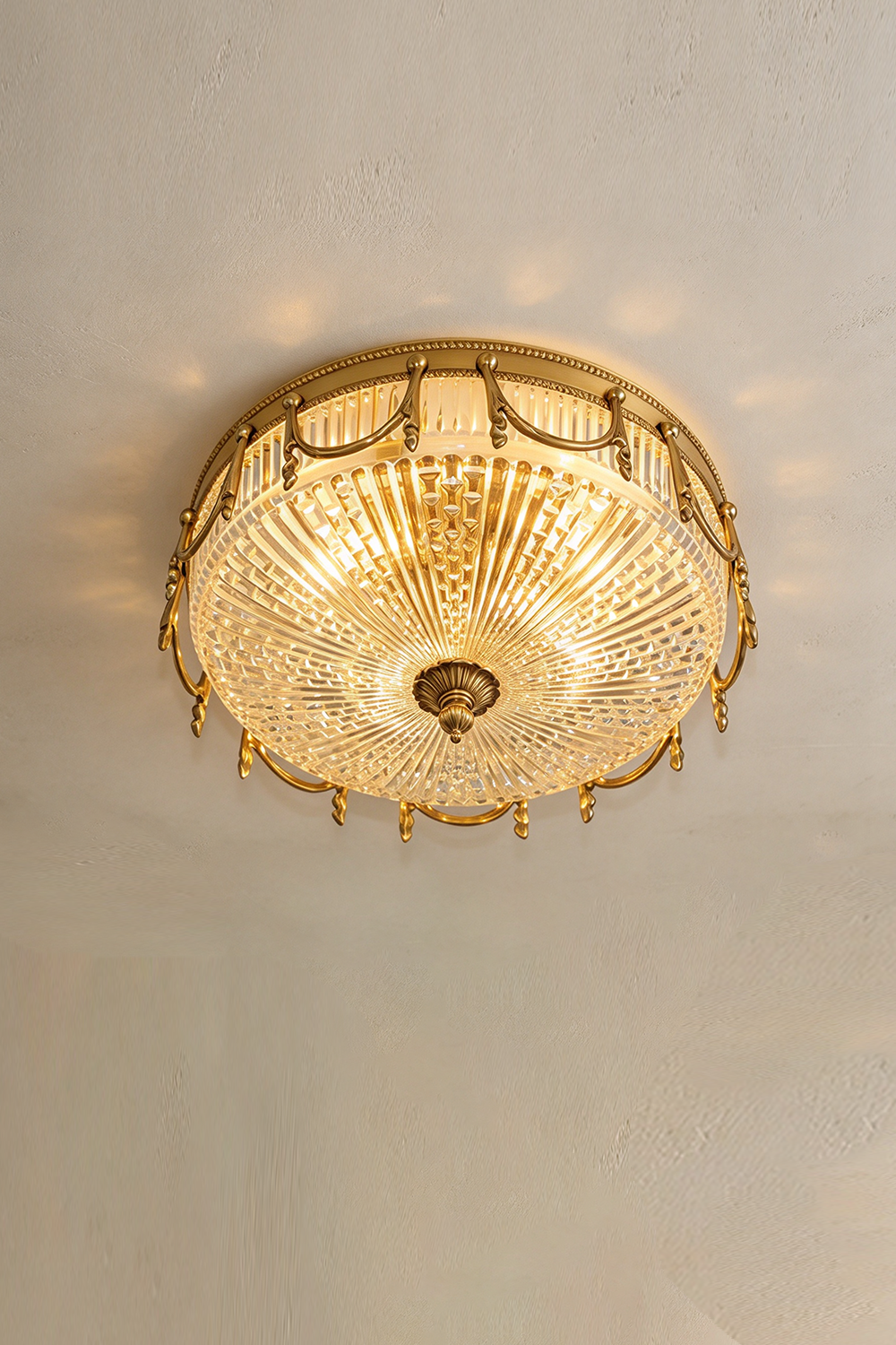 Chaumelle Brass Swag Ribbed Glass Ceiling Light | Ribbed Glass and Brass | Flush mount variant glowing brightly against a plain ceiling | Samu Lamp