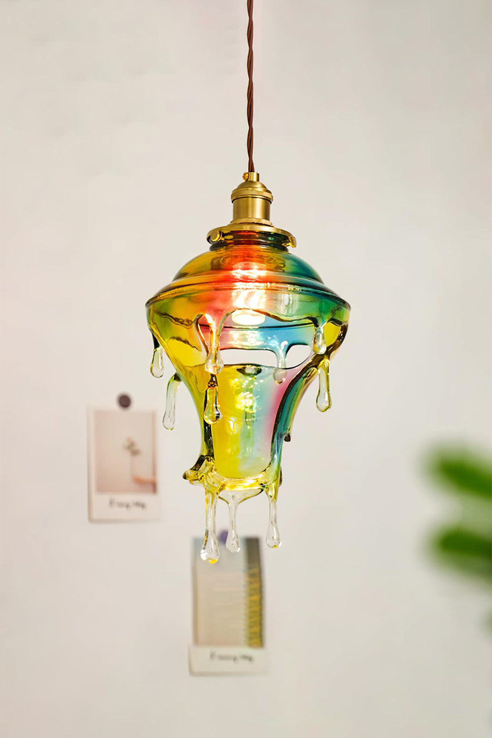 Chroma Drip Rainbow Resin Pendant Lamp | Resin, Metal | Frontal view of the lit multi-color melting drip lamp suspended elegantly against a light neutral studio wall | Samu Lamp