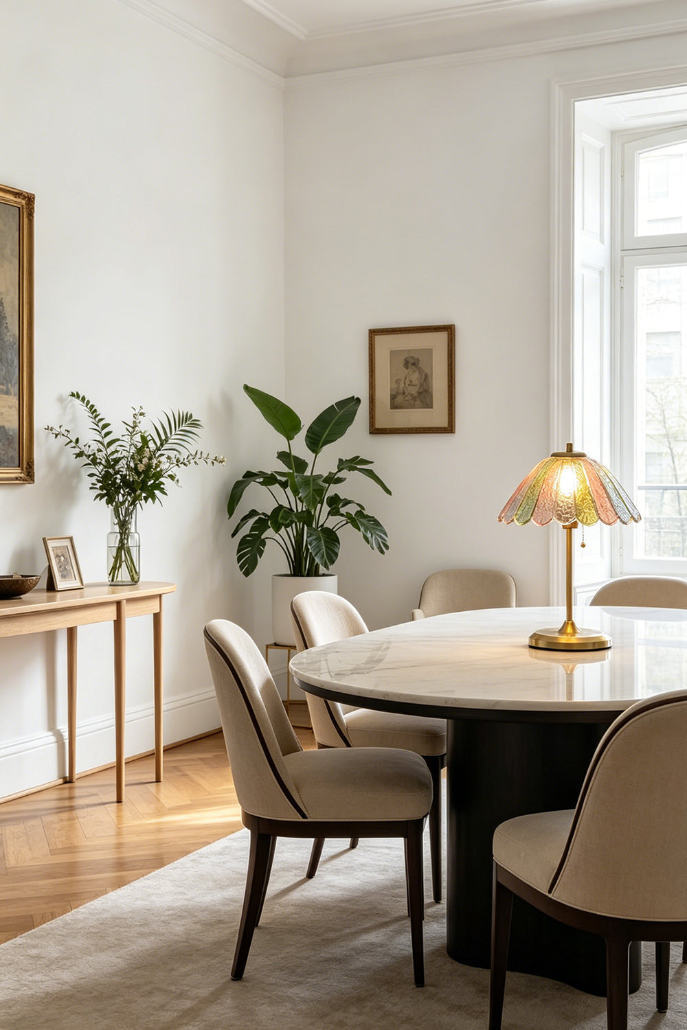 Clara Vintage Pastel Glass Table Lamp | Glass, Metal | Serving as an elegant centerpiece on a large round wooden dining table surrounded by cream chairs | Samu Lamp