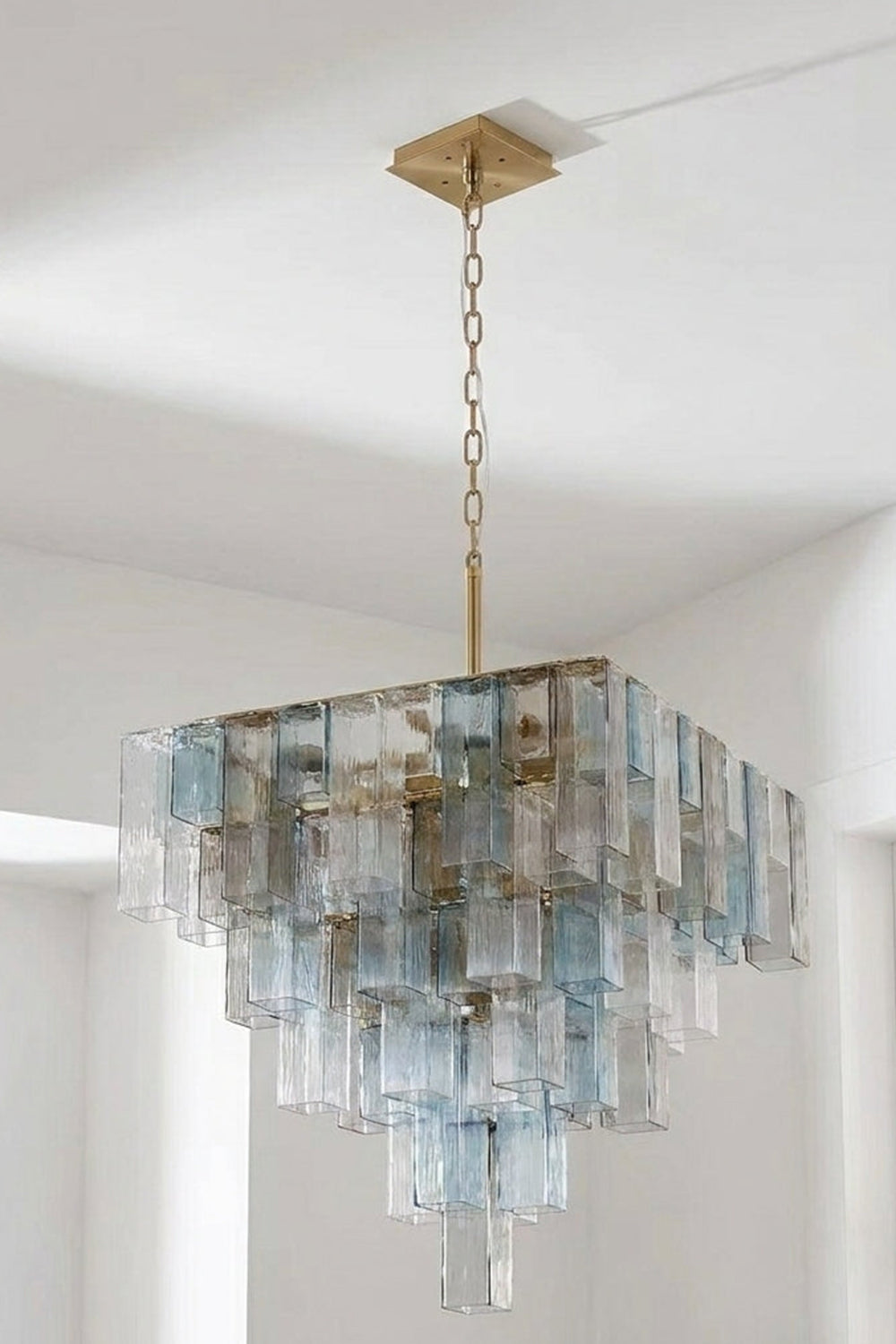 Clarissa Tiered Square Glass Chandelier | Studio Hanging View | Another illuminated studio shot of the multi-tiered square crystal-like pendant lamp fixture against a light backdrop | Samu Lamp