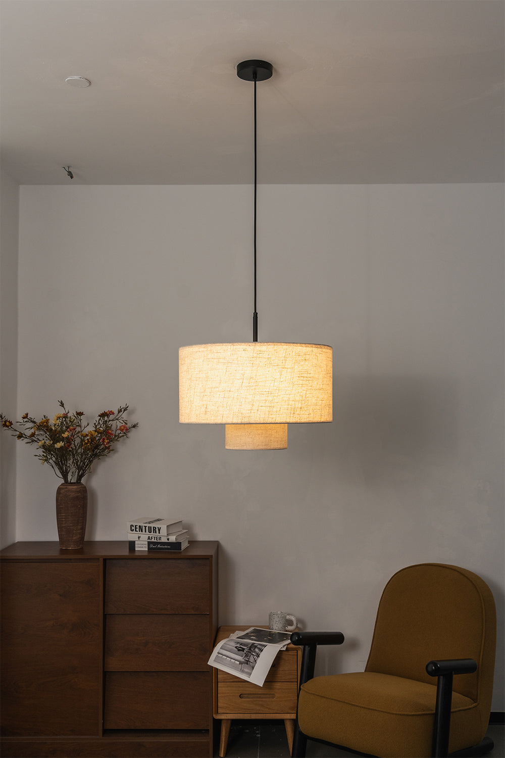 Concentric Veil Fabric Pendant Light | Fabric | Lit pendant near an armchair and wooden chest of drawers | Samu Lamp